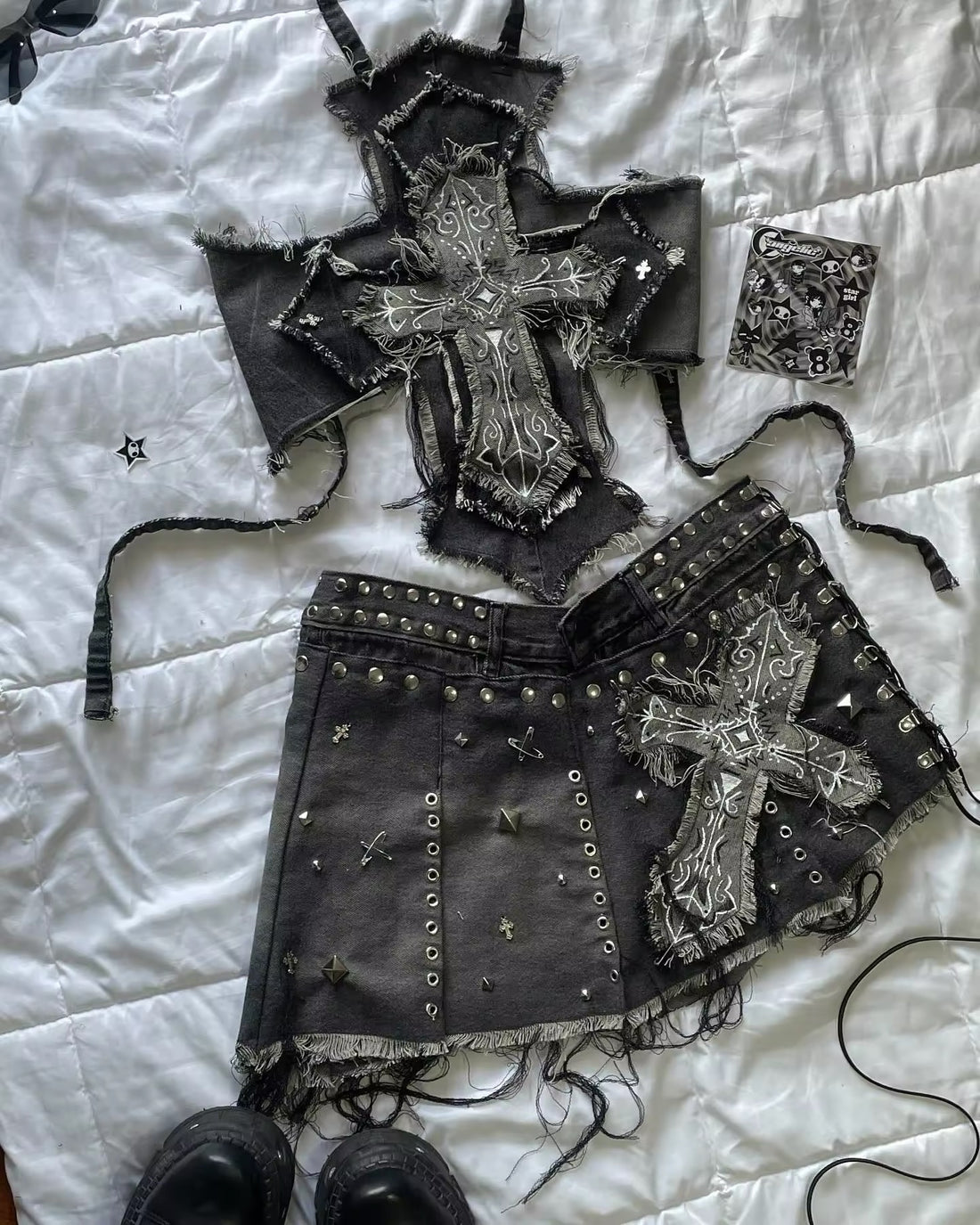 Black denim mini skirt and cropped top with embroidered cross design and silver studs