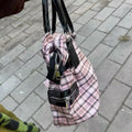 Model walking in an urban setting, the bag complementing her e-girl look.