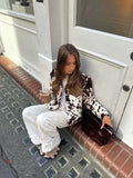 Statement cow pattern coat featuring long sleeves, wool blend fabric, and cropped silhouette for bold autumn layering