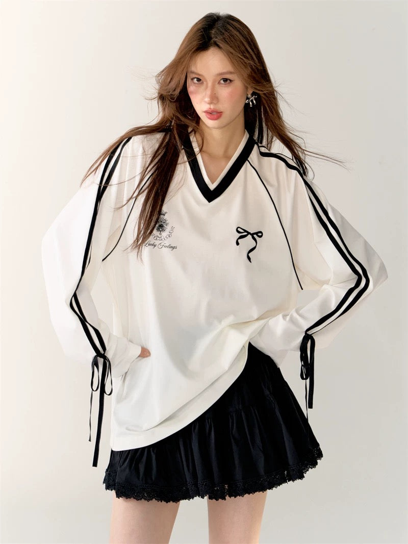 Front view of the Coquette Sporty Top in white with black stripes and bow detail.