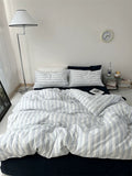 Bed with striped bedding in a bedroom setting