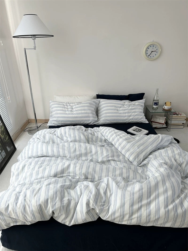 Bed with striped bedding in a bedroom setting