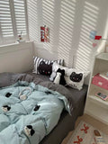 Bedroom with cat-themed bedding and pillows, sunlight filtering through shutters.