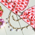 Close-up of the gold belly chain with ceramic tulip bead charms and pearls.
