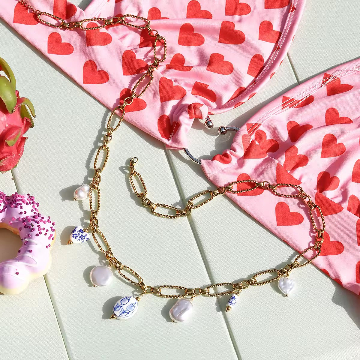Close-up of the gold belly chain with ceramic tulip bead charms and pearls.
