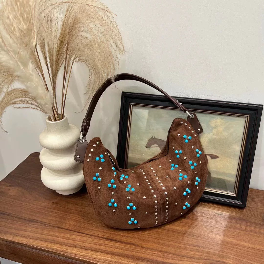Brown boho shoulder bag with turquoise bead details on plain background