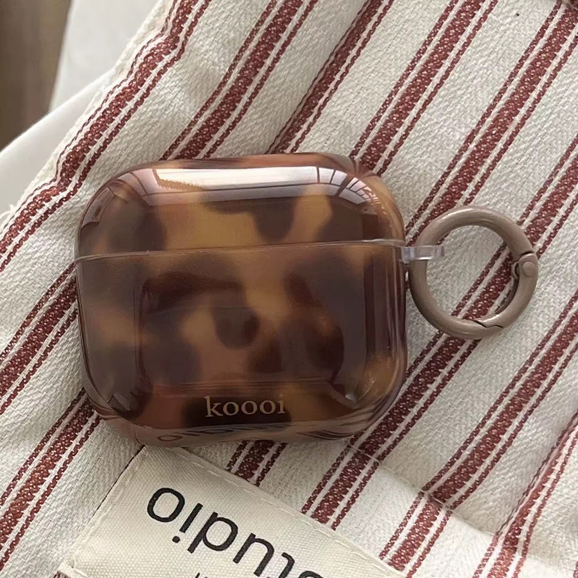 Brown amber AirPods case with glossy leopard pattern