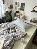 Bedroom with a bed, books, and a laptop on a shelf.
