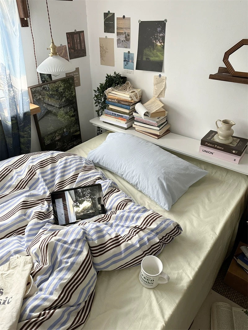 Bedroom with a bed, books, and a laptop on a shelf.