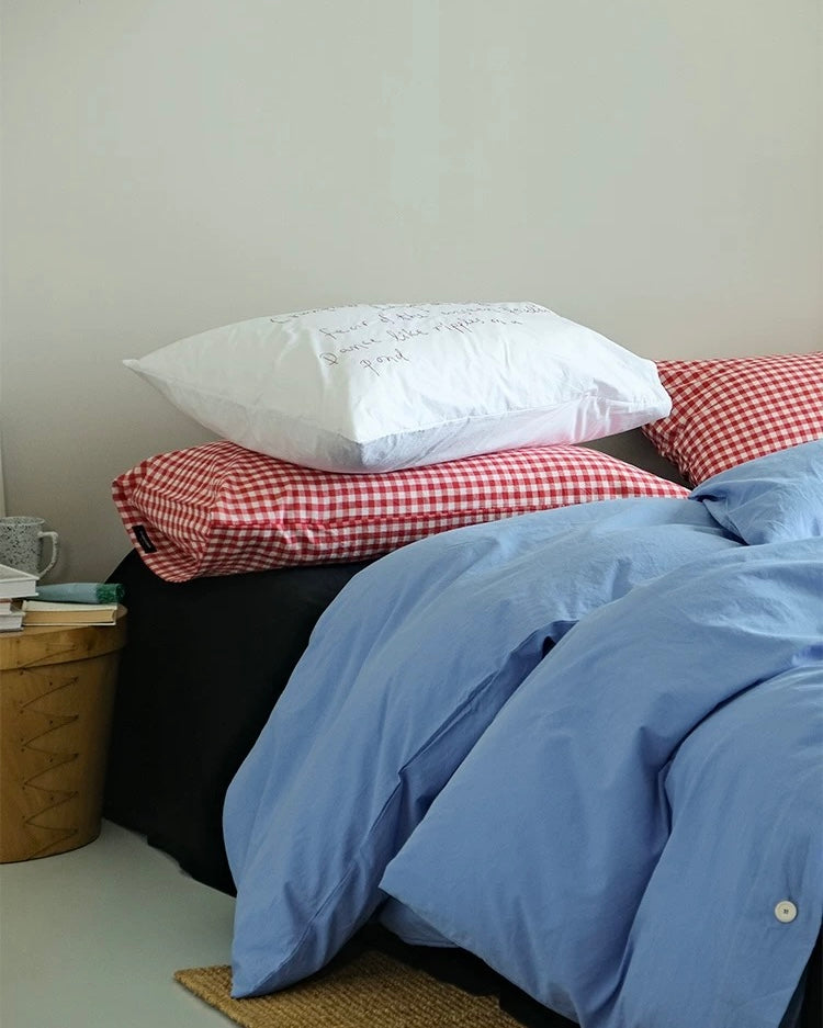 Korean minimalist bedroom featuring blue cotton duvet and plaid pillows