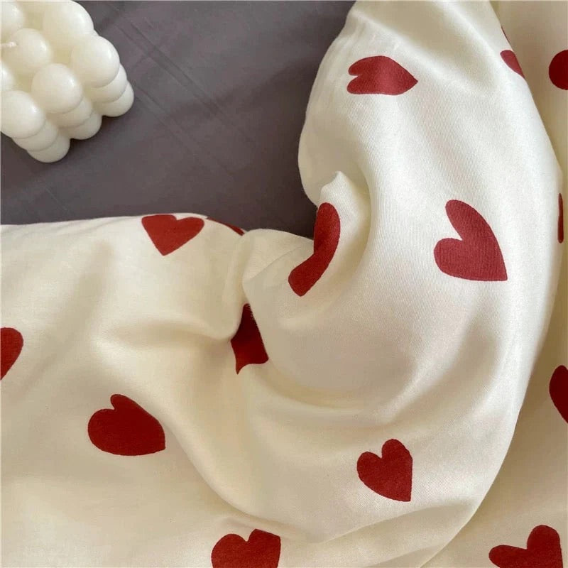 White fabric with red heart patterns on a neutral background