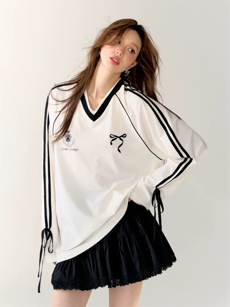 Front view of the Coquette Sporty Top in white with black stripes and bow detail.