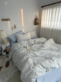 Neatly made bed with light-colored bedding in a bedroom setting.