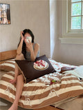 Person taking a mirror selfie on a bed with a cake on a pillow