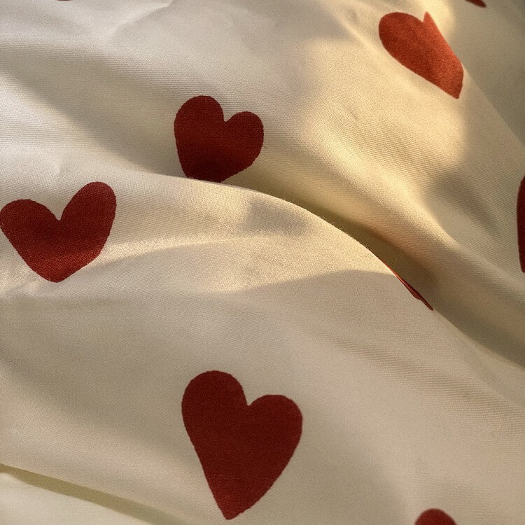 Close-up of beige fabric with red heart patterns