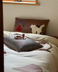 Bed with decorative pillows and a small table setup in a room.