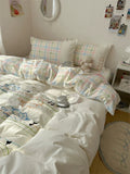 Bed with pastel-colored bedding and pillows in a room setting.