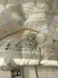 Children's bedding set with cartoon designs on a bed.