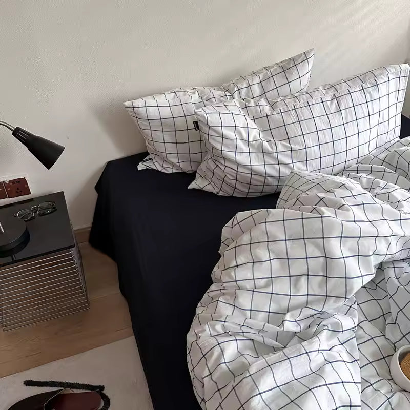 Bed with checkered bedding and pillows in a bedroom setting.