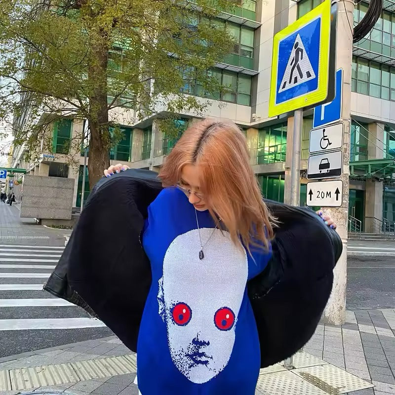 Close-up view of red eyes and pixelated print on blue face sweater for Harajuku fashion
