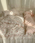 Floral bedding set with ruffled edges on a bed.