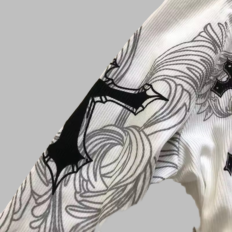 Close-up of a white garment with black floral patterns on a textured surface