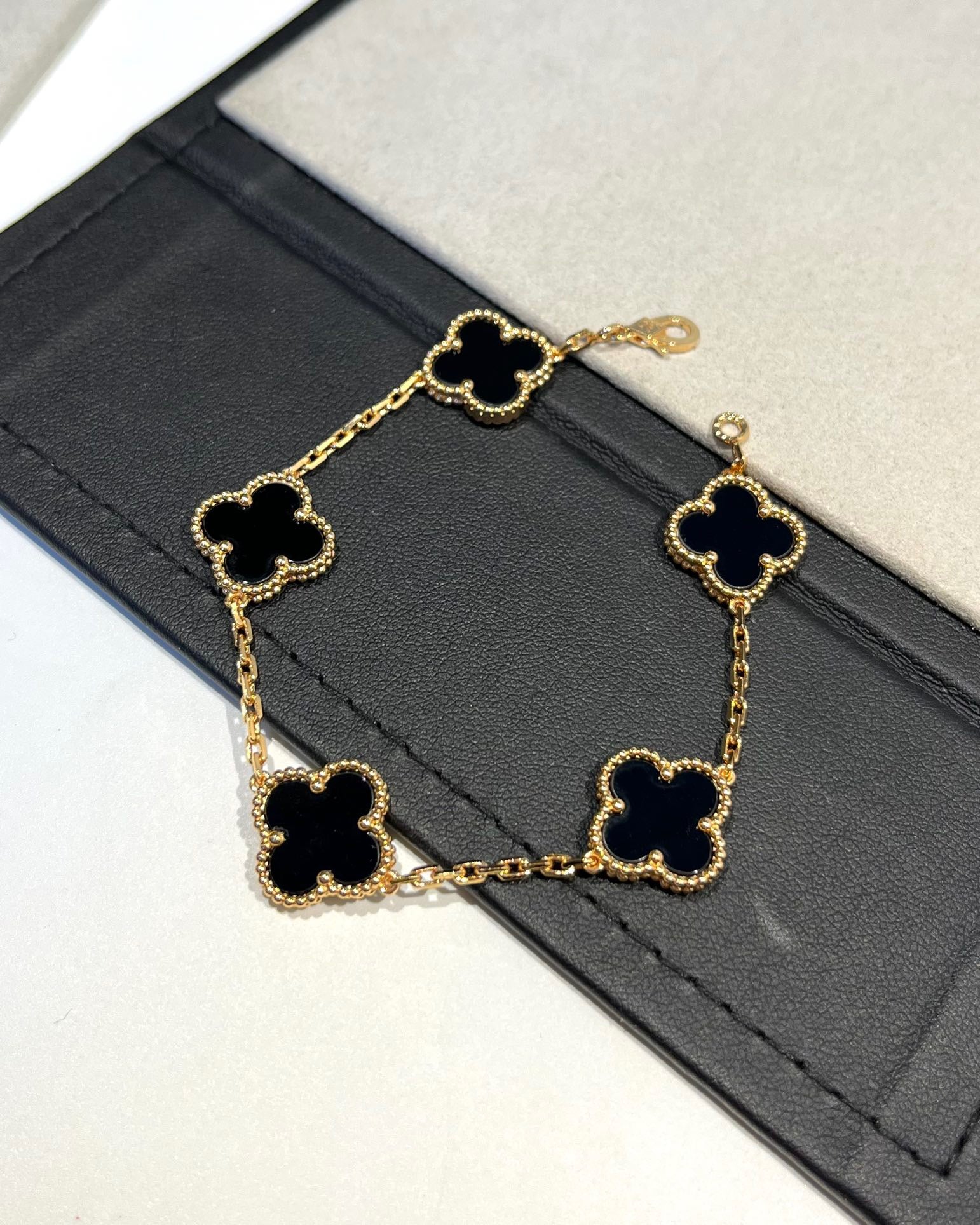 Bold black enamel bracelet with lucky clover charm