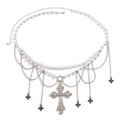 Gothic pearl belly chain with cross charm and tassels, worn over black mini skirt