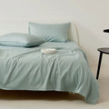 Light blue bedding set on a bed with a neutral background