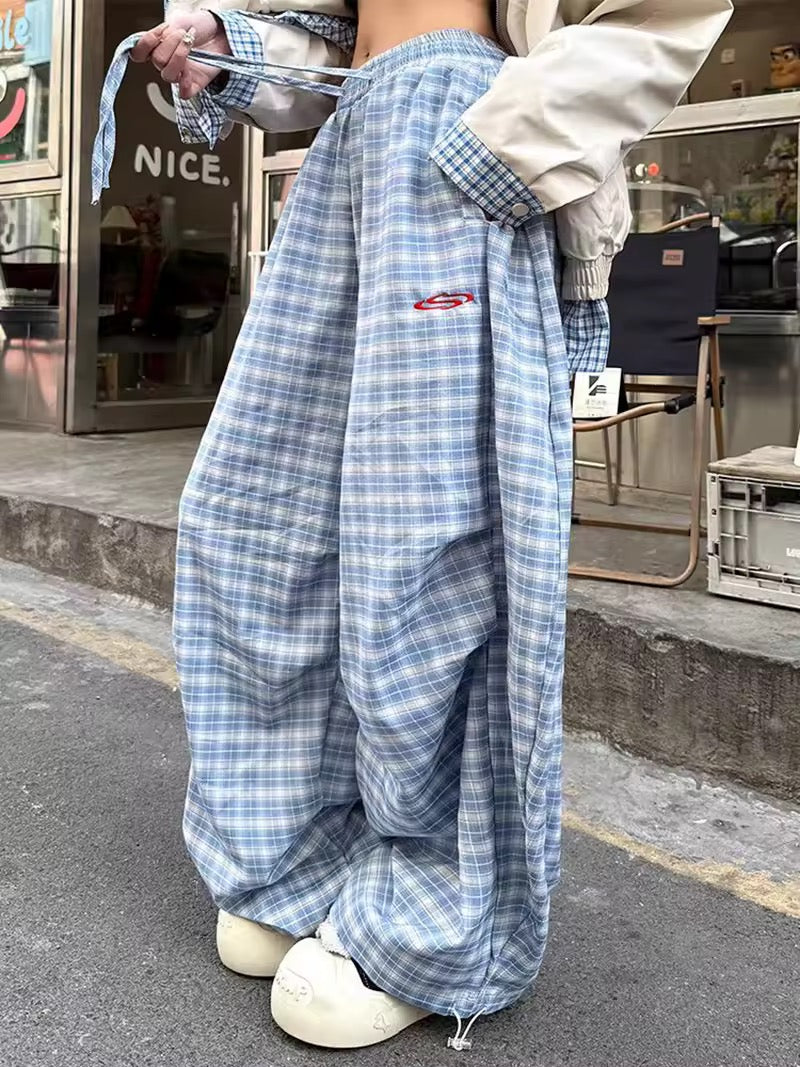 Model lounging in wide leg pants with hoodie and slippers for cozy Y2K look