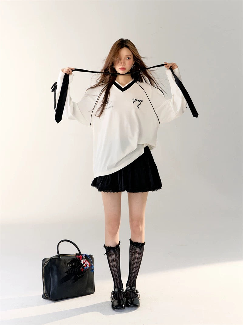 Black oversized jersey with white stripes styled with a sporty hat.