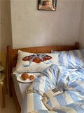Bed with blue and white striped bedding, a plate of pastries, and a telephone on a nightstand.