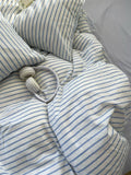 Striped bedding with a pair of headphones on a bed