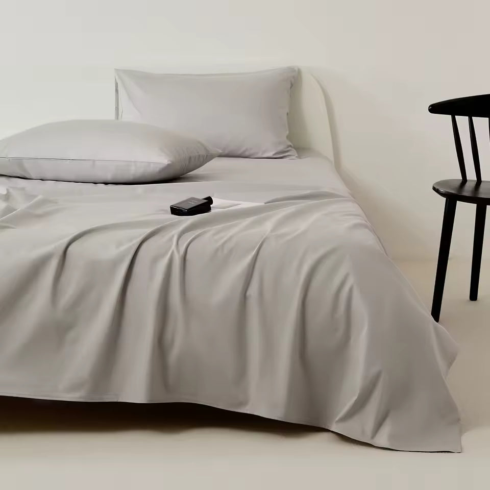 Gray bedding set on a bed with a minimal background