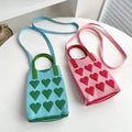 Compact knitted heart handbag on white background