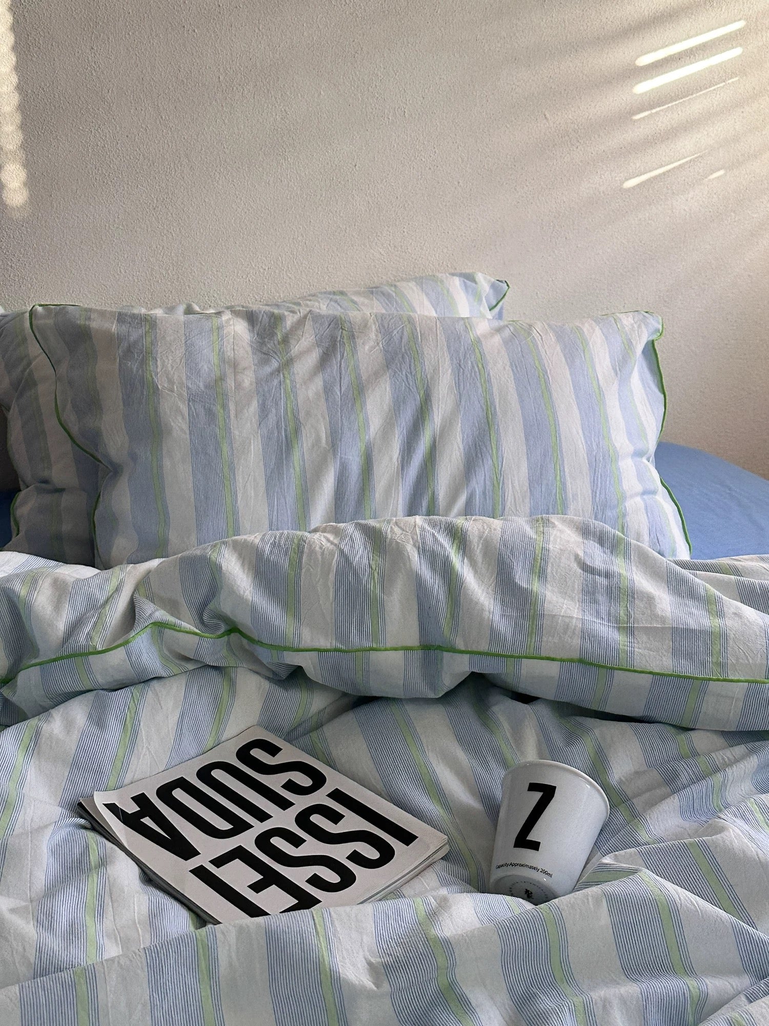 Striped bedding with pillows and a card on a bed