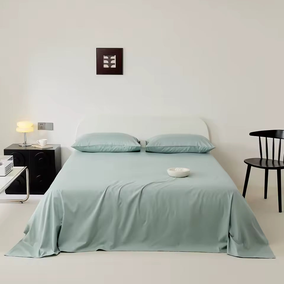 Bedroom with a bed covered in light green bedding, nightstands, and a chair.