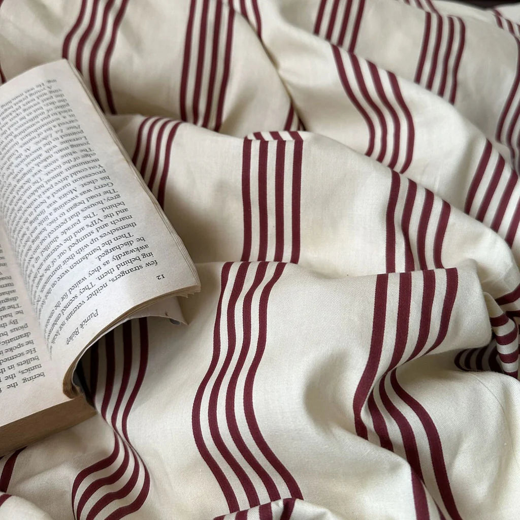 Open book on a white fabric with red stripes