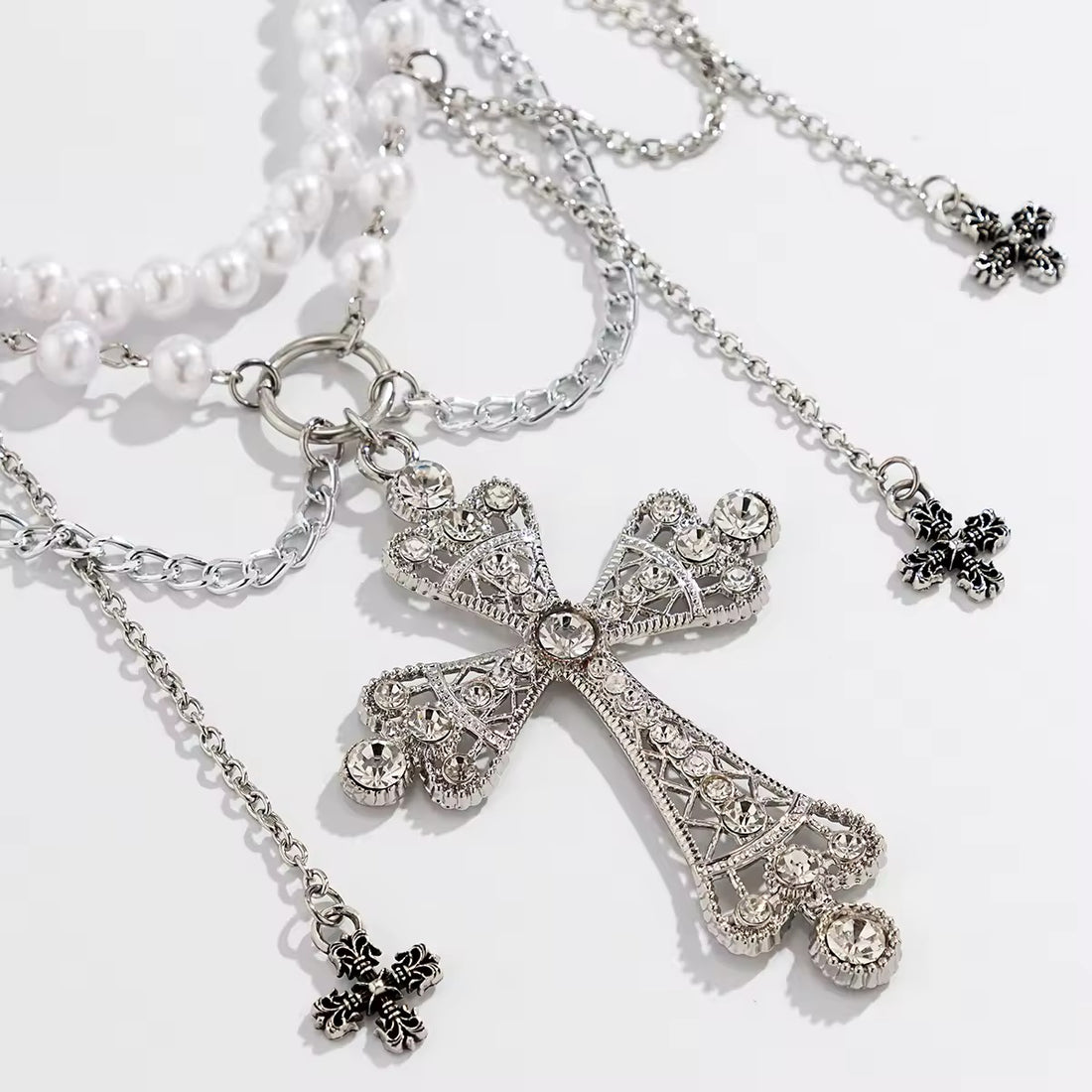 Gothic pearl belly chain with cross charm and tassels, worn over black mini skirt
