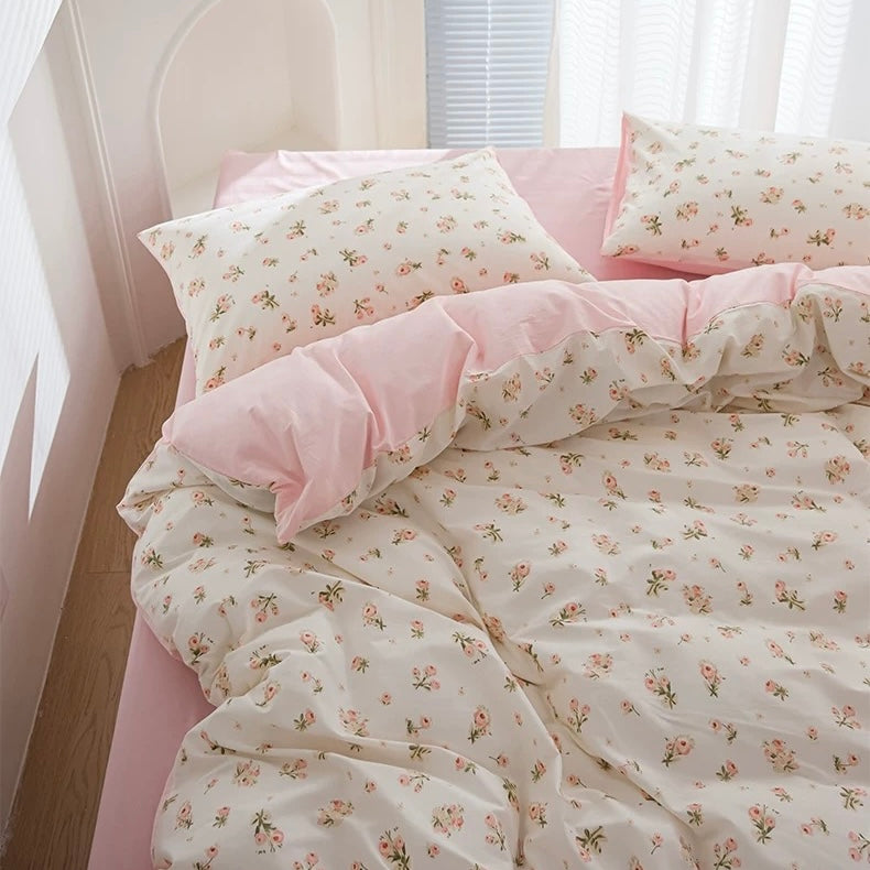 Floral bedding set on a bed with a nightstand in the background