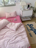 Bedroom with pink bedding and a nightstand, featuring a 'So Sweet Day' rug.