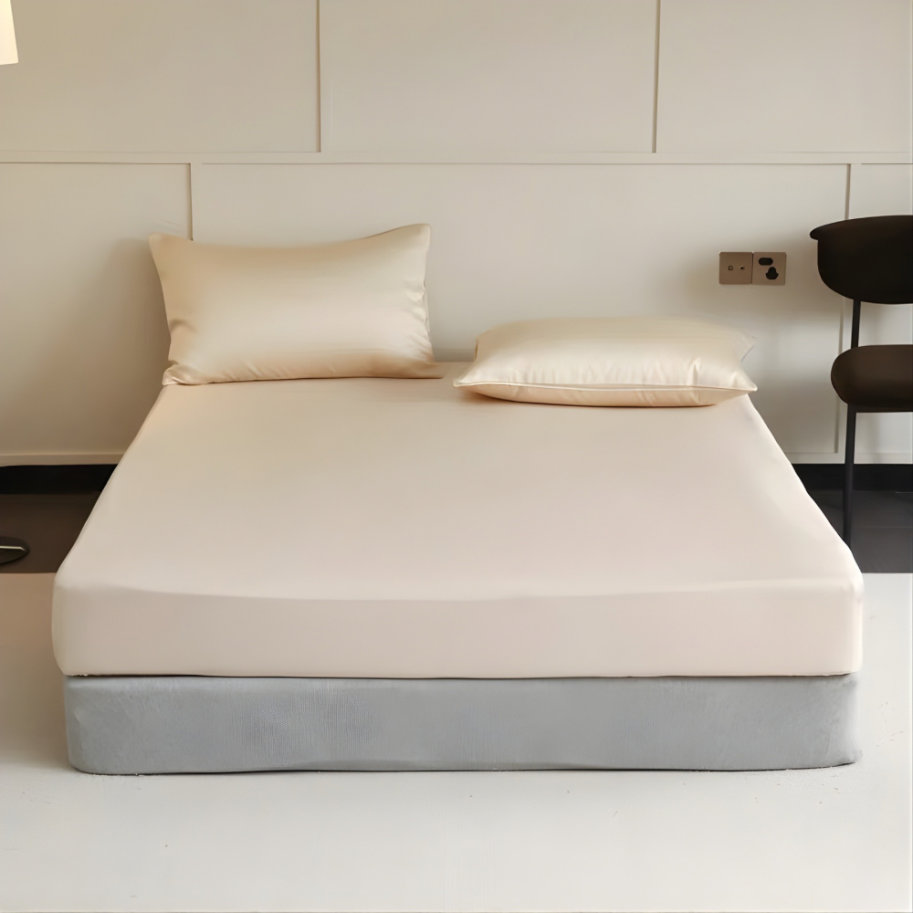 Bed with beige mattress cover and pillows in a minimalistic room.
