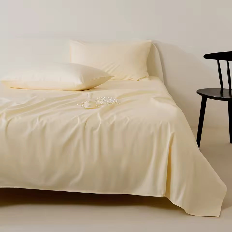 Beige bedspread with floral design on a bed against a white wall.