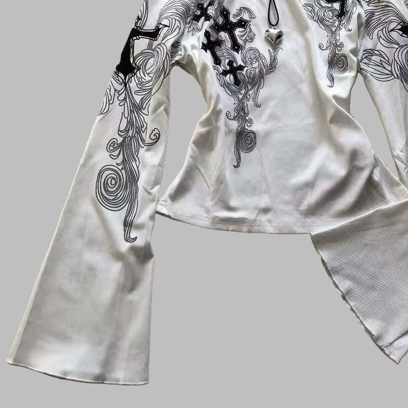 White outfit with black floral patterns on a textured surface