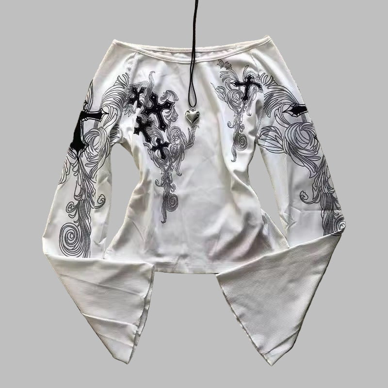 White outfit with black embroidery on a textured surface