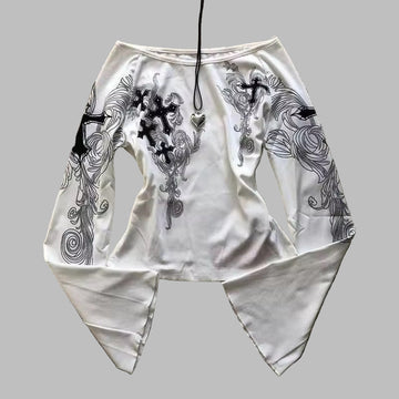 White outfit with black embroidery on a textured surface