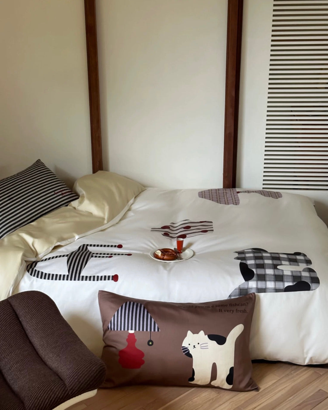 Bed with cartoon-patterned bedding and pillows in a room setting.