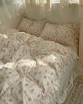 Floral patterned bedding set on a bed with light curtains in the background