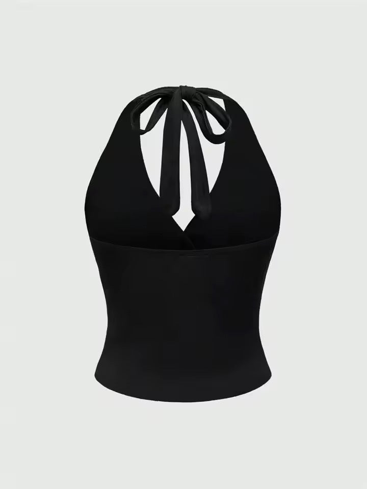 Black halter top with bow detail on a light gray background