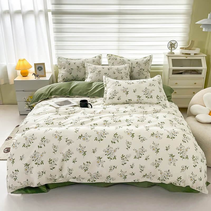 Floral bedding set on a bed in a bedroom with white walls and furniture.